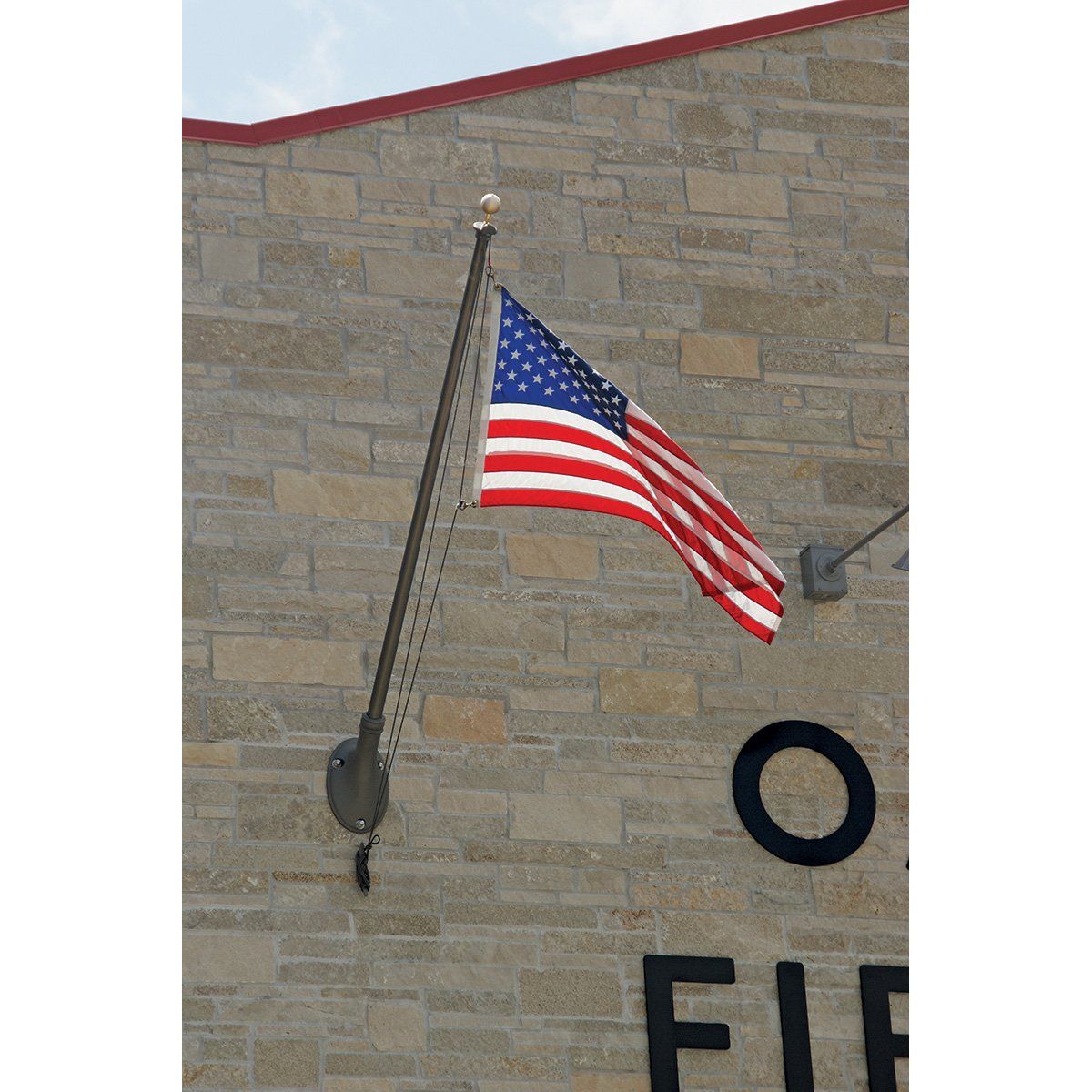 An american flag is hanging from a pole on the side of a building