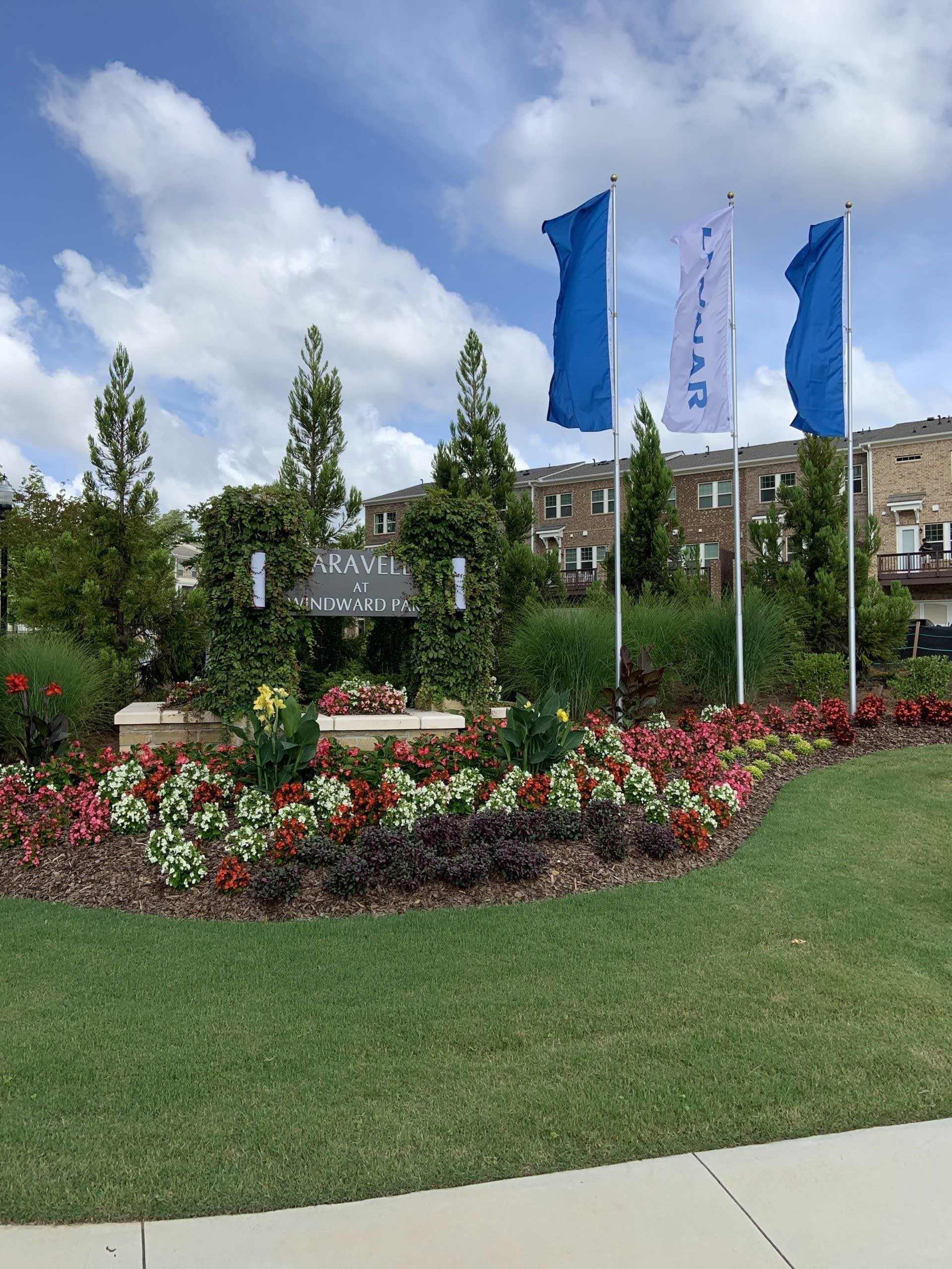 A garden with flowers and flags in front of a building