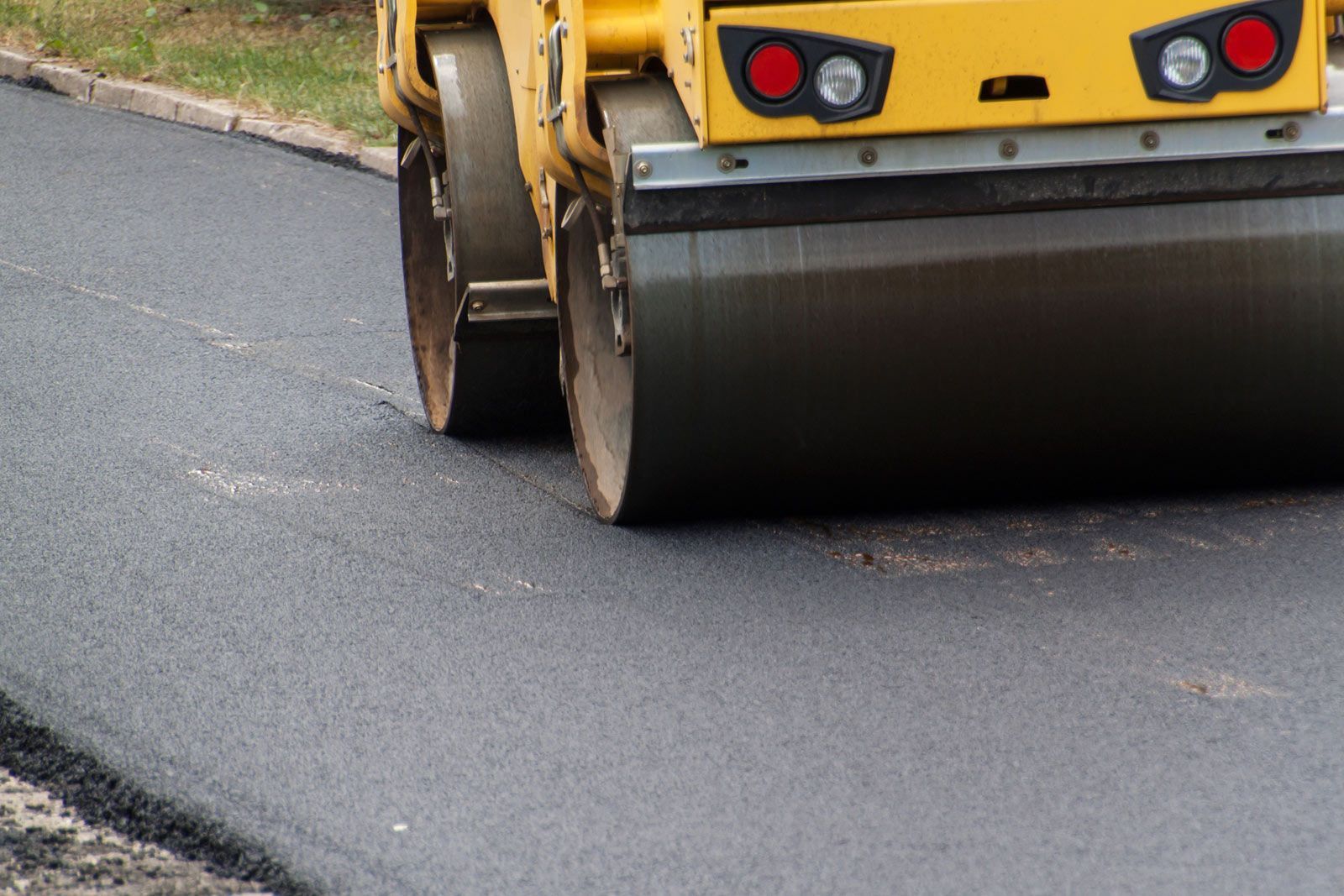 Asphalt roller compacting fresh asphalt on road