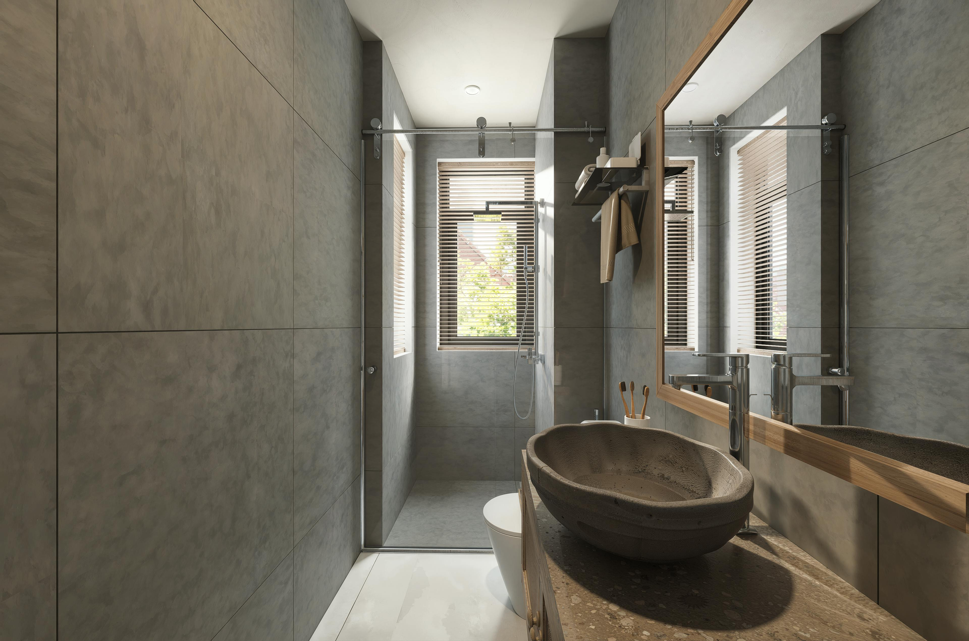 A modern bathroom with gray tiled walls, a stone vessel sink on a textured vanity, and a windowed shower area.