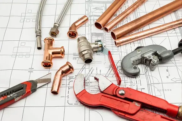 Pipes and tools are lying on a blueprint.