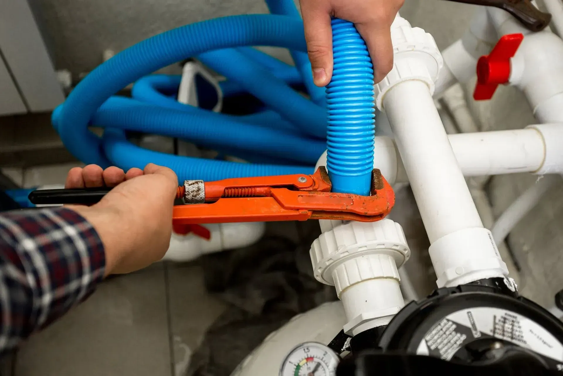 A man is fixing a pipe with a wrench.