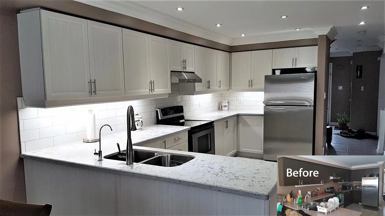 Updated kitchen with white cabinets, quartz countertops, and stainless steel appliances.