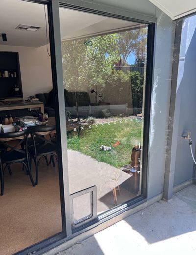 A Sliding Glass Door Leading To A Patio With A Cat Door — SG Glass & Aluminium in Wagga Wagga, NSW