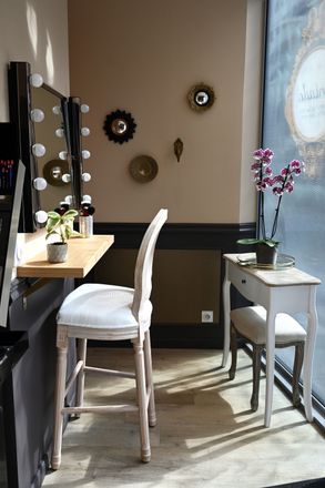 Une pièce avec une table, des chaises, des miroirs et une fenêtre.