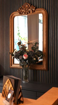 Une chambre avec un lit et un miroir au mur