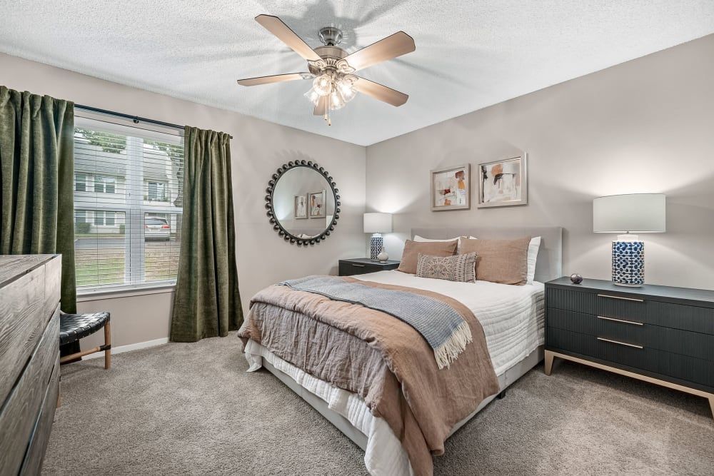 a bedroom with a bed , dresser , lamp and ceiling fan at The Park at Flower Mound in Flower Mound, TX.