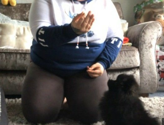 Woman holding treats out for a puppy in a video call.
