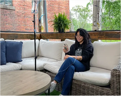 A man is sitting on a couch talking to a nurse in a living room.
