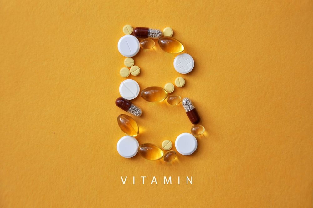 The letter b is made of pills and capsules on a yellow background.