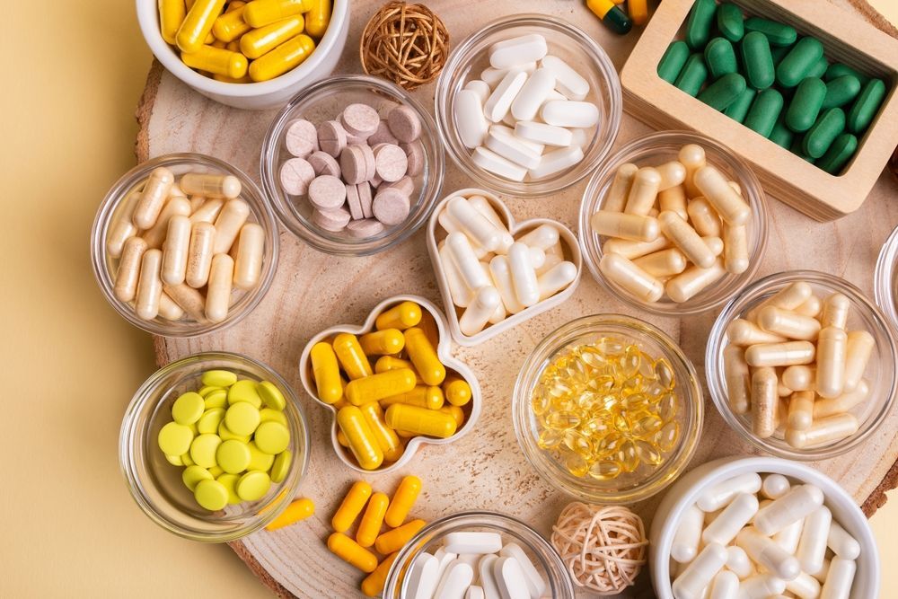 There are many different types of pills and capsules on the table.