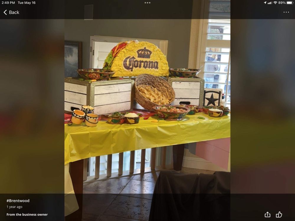 Taco-themed food table with Corona taco piñata and food, on a yellow tablecloth.