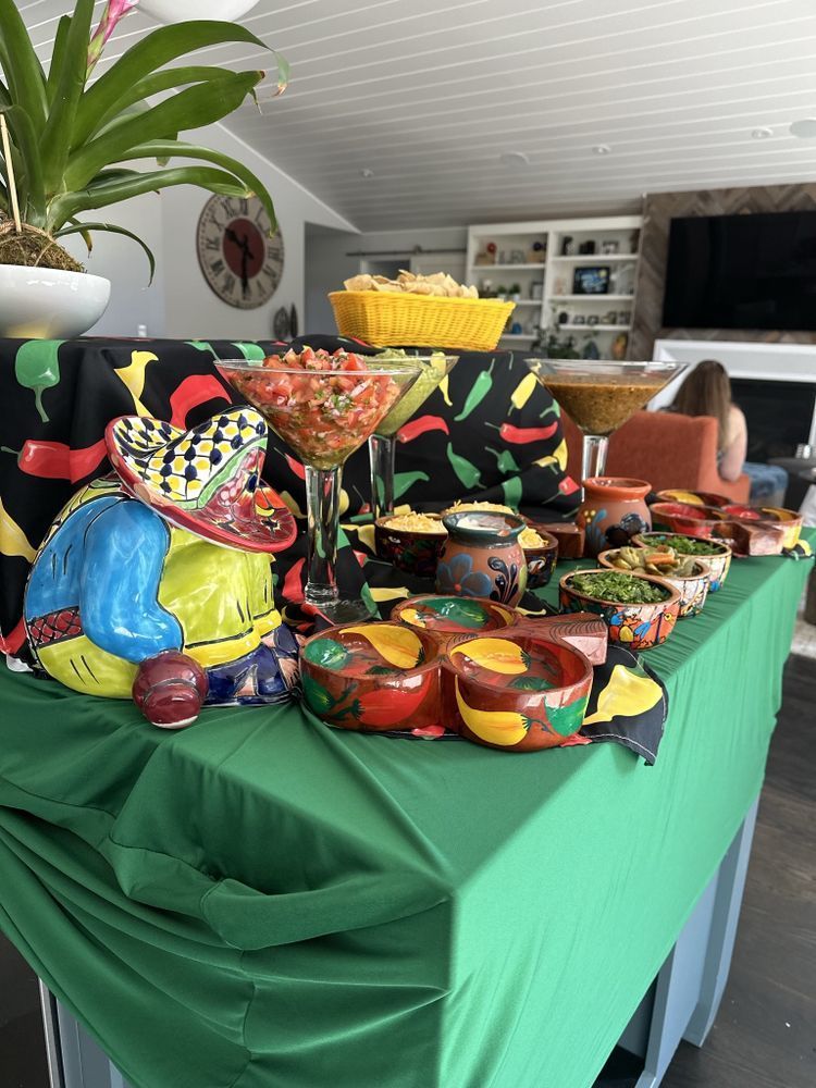 Mexican food spread: chips, salsa, guacamole, and decor on a table.