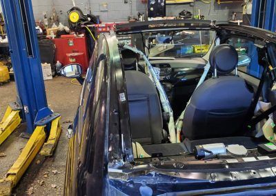 A car is sitting on a lift in a garage.