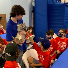 A Man Showing a Rabbit for the Kids in a Summer Camp A Man Showing a Rabbit for the Kids in a Summer Camp