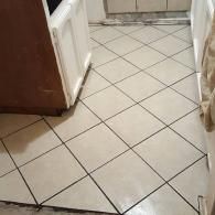 Interior floor with white diamond-pattern tiles and brown cabinets along the sides.