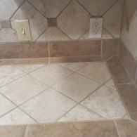 Kitchen countertop with beige tile backsplash and electrical outlets