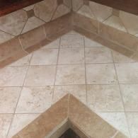 Beige tiled floor with a decorative chevron pattern and brown trim along the edges.