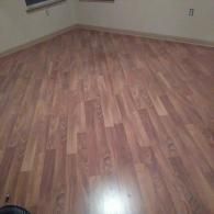 Empty room with light wood laminate flooring and beige walls