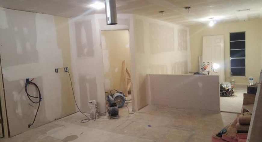 Partially finished room with drywall, tools, and construction materials on the floor