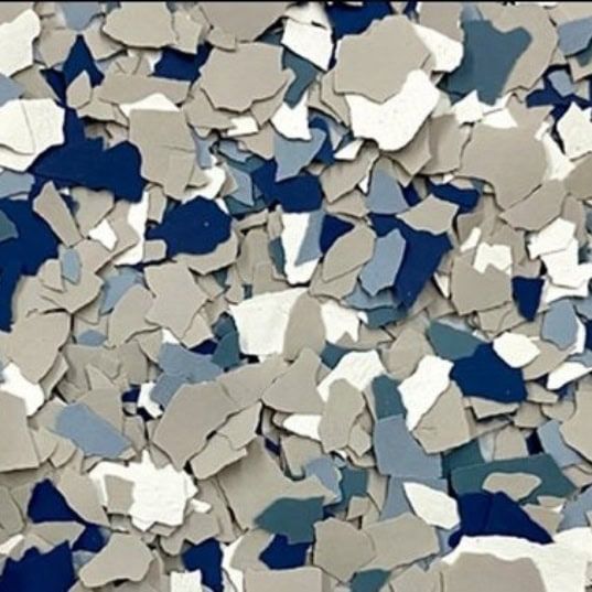 Abstract mosaic of small overlapping blue, white, and beige paper-like shapes
