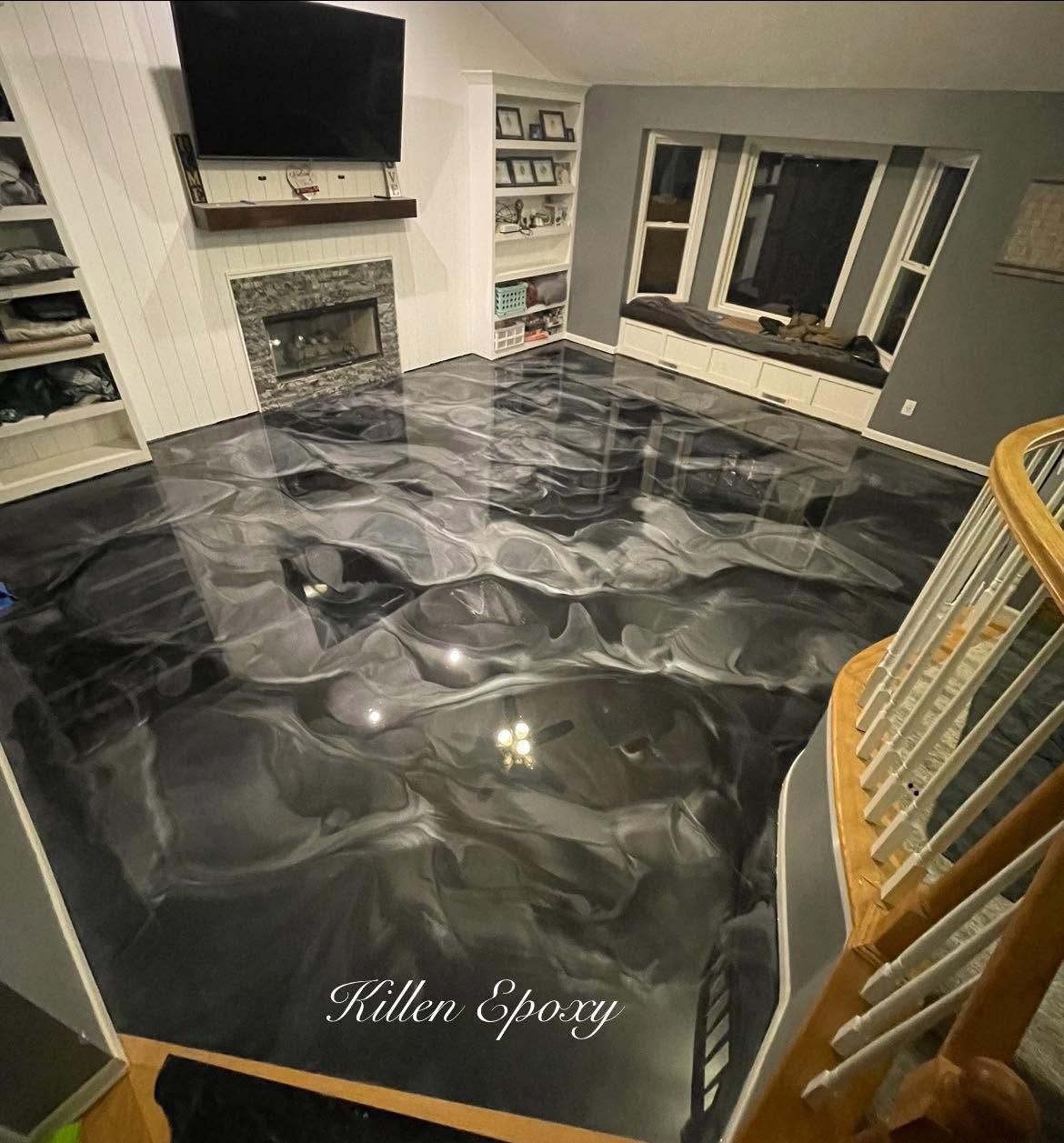 Living room with glossy black marble floor, fireplace, TV, and staircase railings