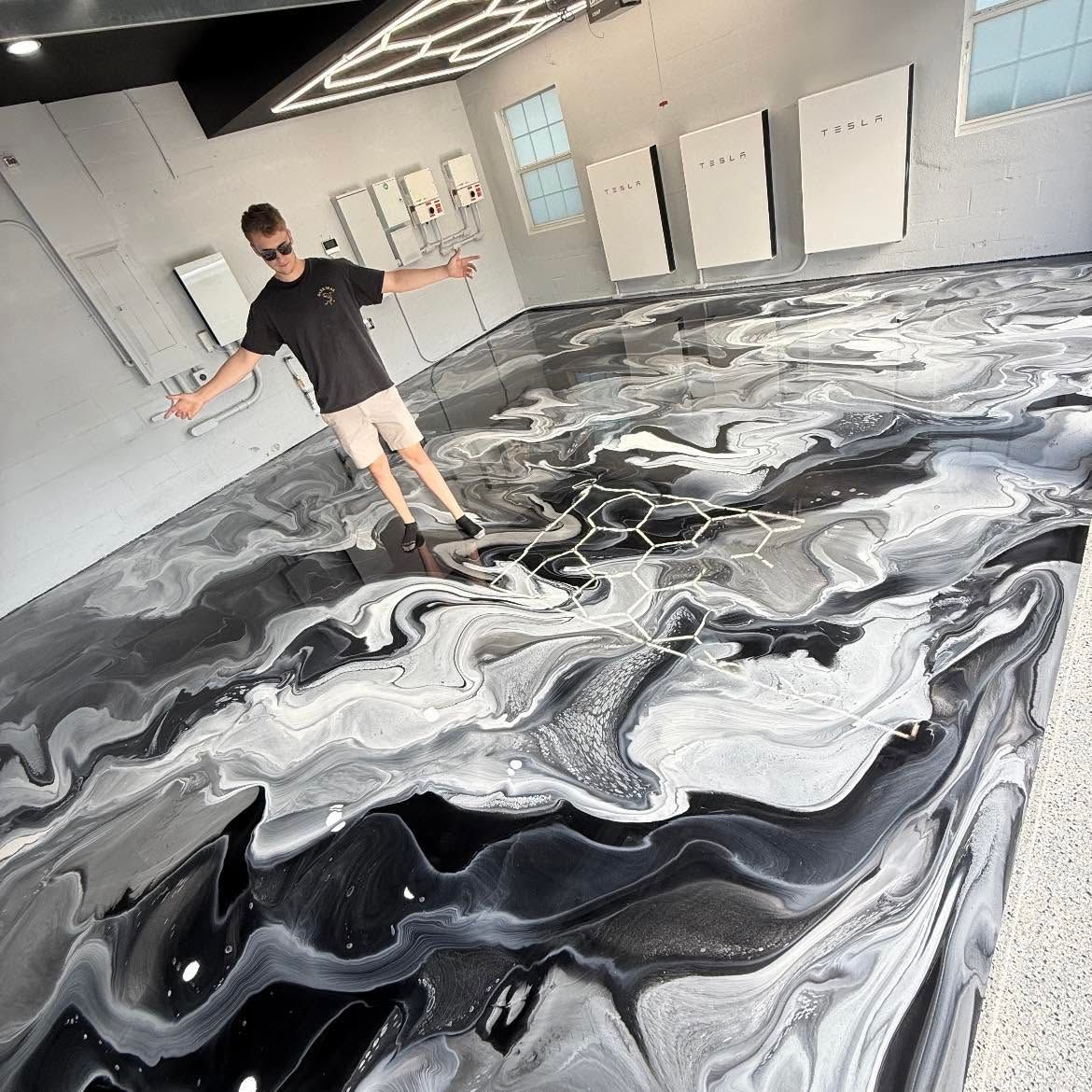 Person standing in a room beside a large black-and-white marbled floor design