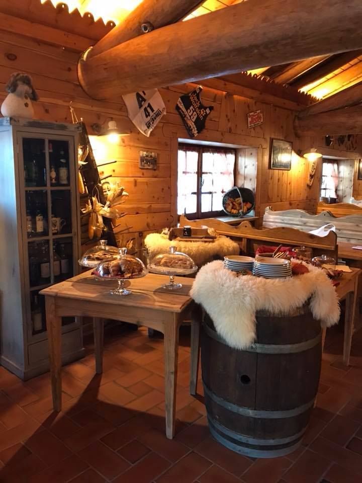 Una stanza di legno con una botte e un tavolo con sopra dei piatti.