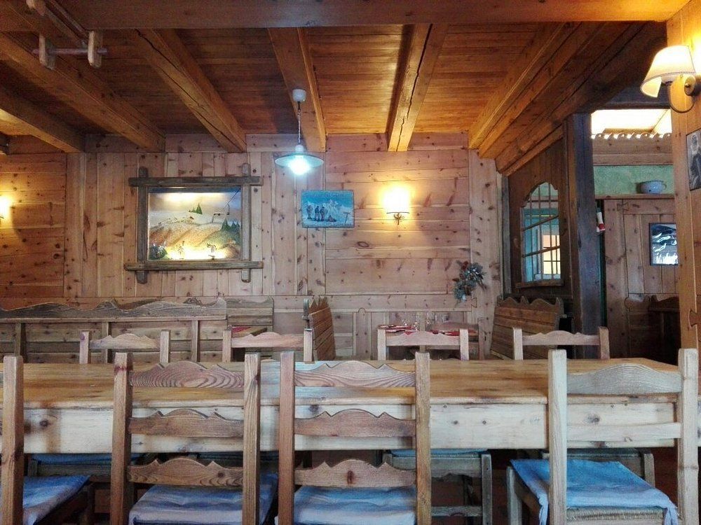 Un ristorante con tavoli e sedie in legno e un quadro sul muro