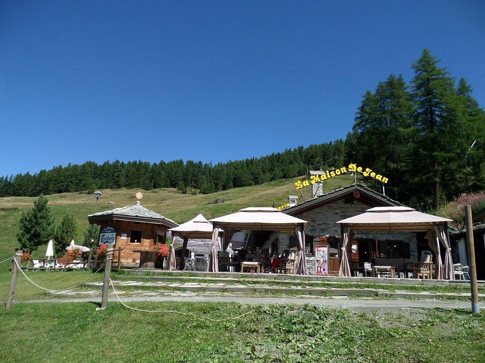 Un gruppo di edifici si trova in cima a una collina erbosa.