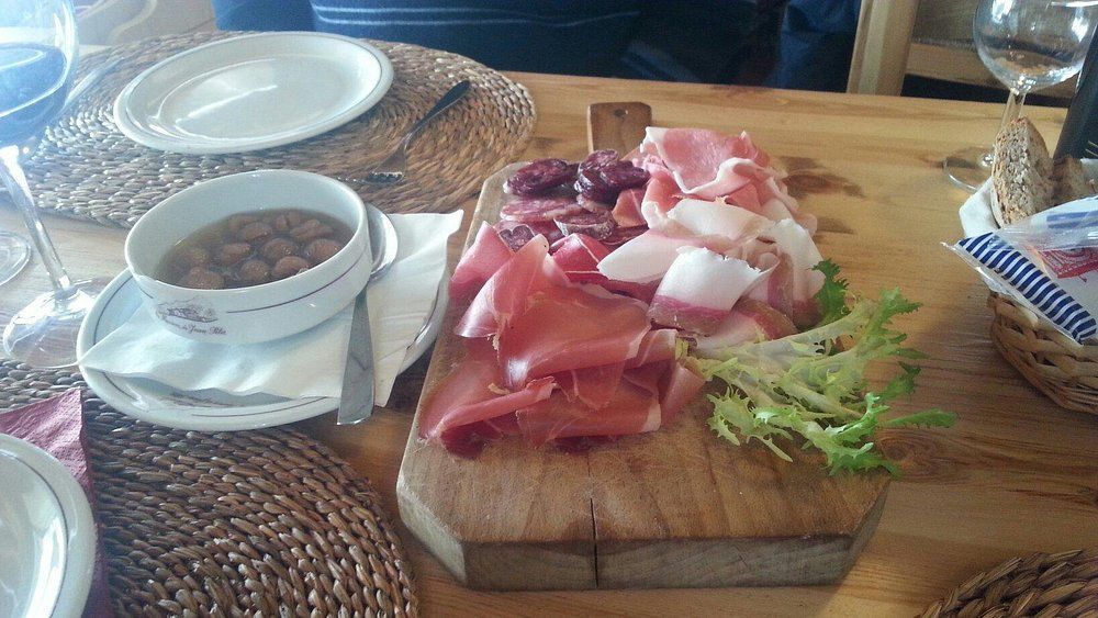 Un tagliere di legno con carne e verdure sopra