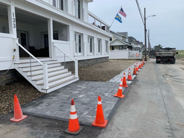 White house with steps and American flag beside a blocked street lined with orange traffic cones
