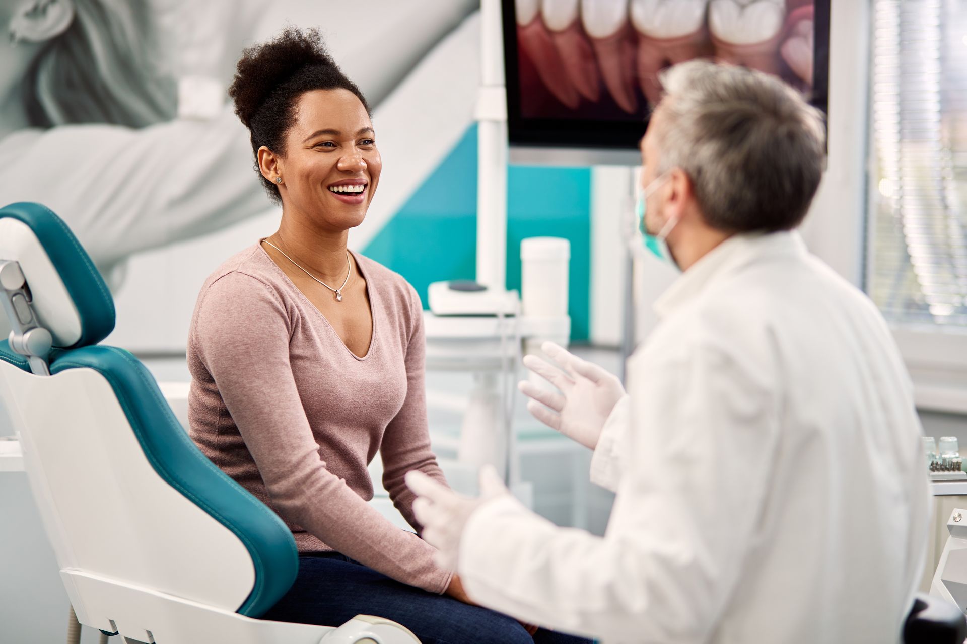 Woman smiling while speaking with a dentist in a modern dental clinic