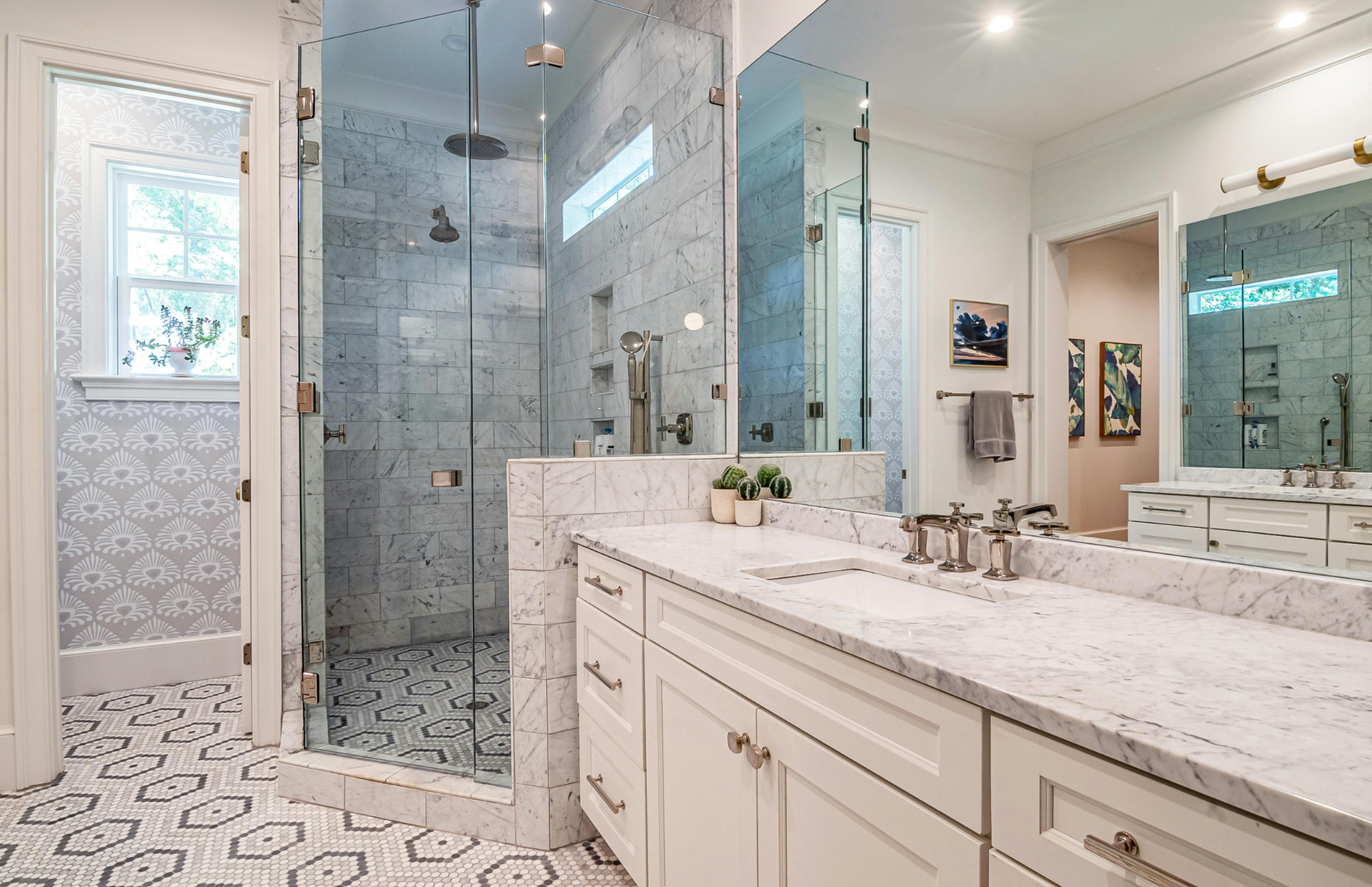 Bright modern bathroom with glass shower, double vanity, and patterned tile floor