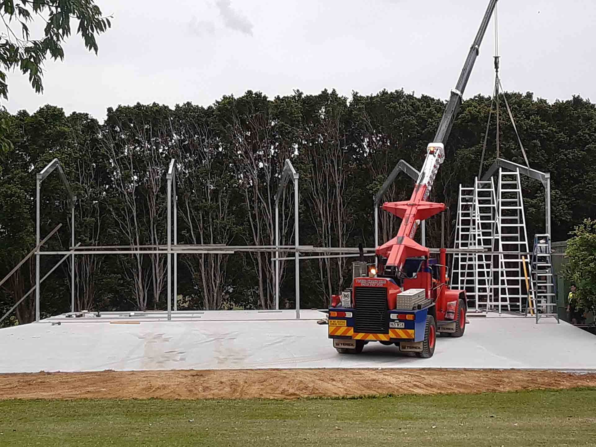 Mobile Crane Parked In Front Of A Building Under Construction — Providing Steel & Concrete Construction In Eviron, NSW