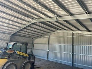 A Forklift Is Parked Inside Of A Metal Building — CJR Group Concrete Construction In Lismore, NSW