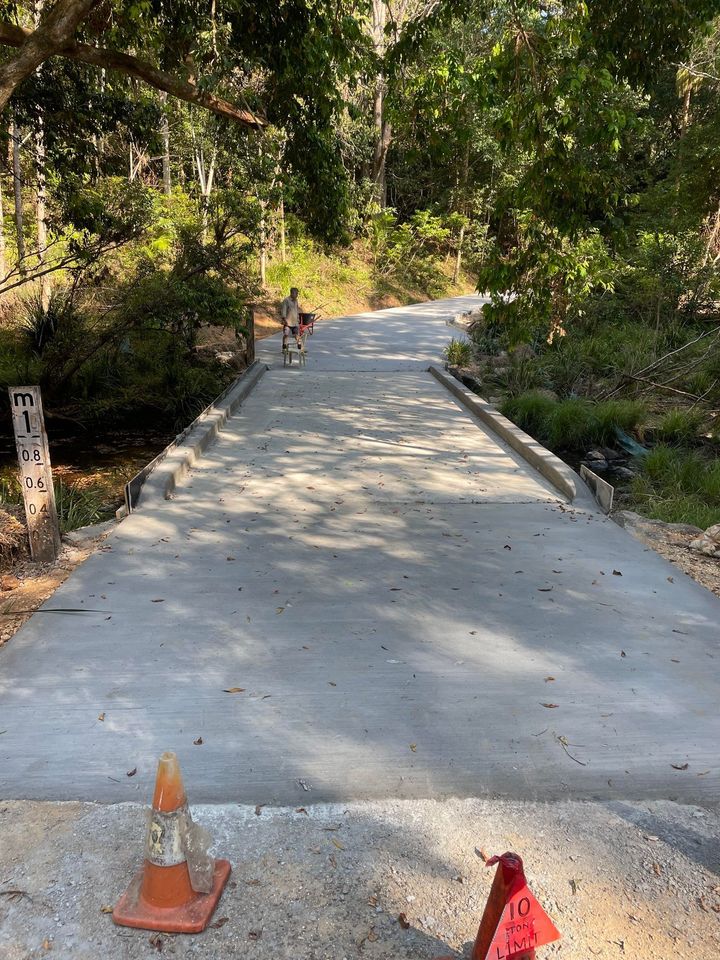 A Concrete Road With a Cone on the Side of It — Providing Steel & Concrete Construction In Eviron, NSW