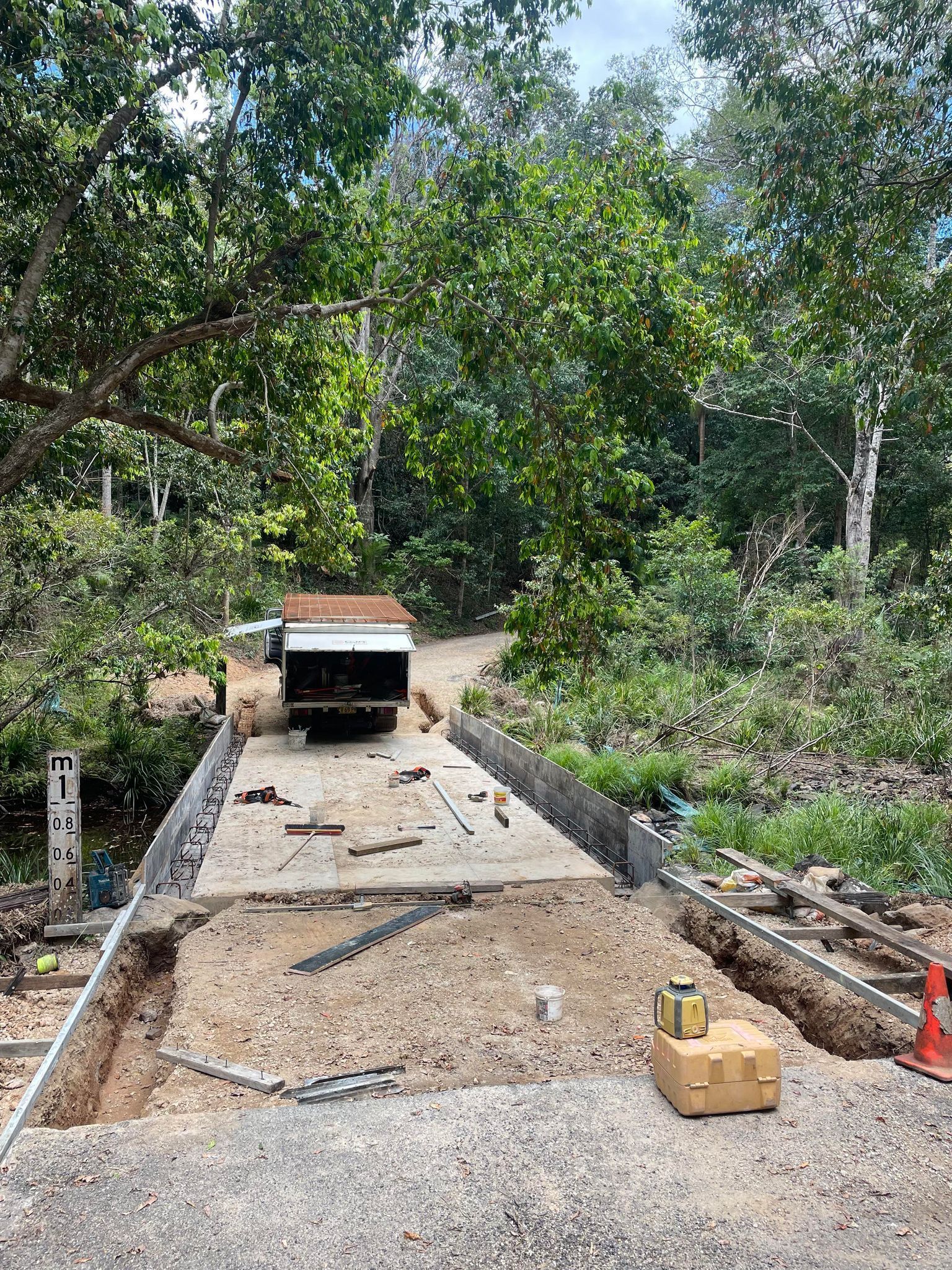 A Truck is Driving Down a Dirt Road in the Woods — Providing Steel & Concrete Construction In Eviron, NSW