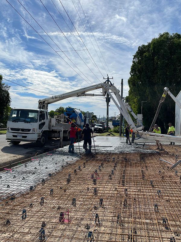 A Concrete Truck Is Pouring Concrete On A Construction Site — CJR Group Concrete Construction In Lismore, NSW