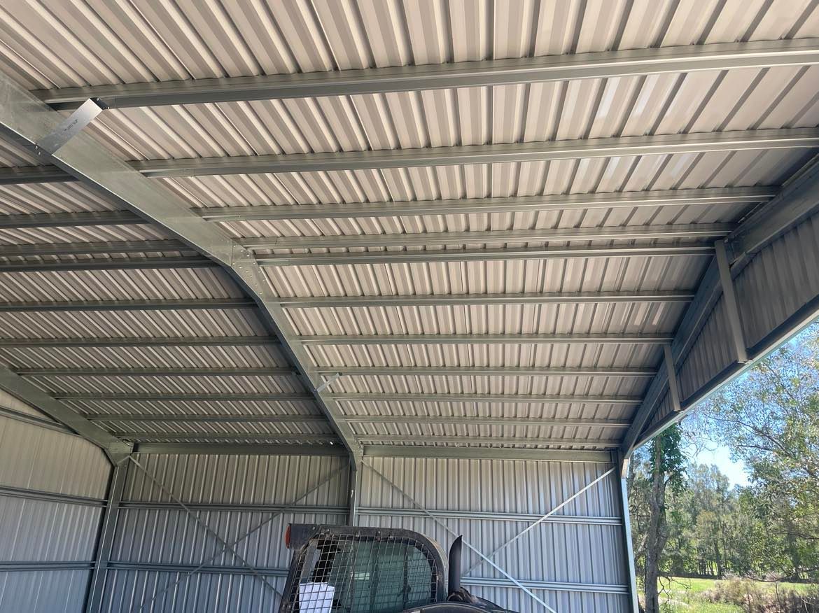Tractor Is Parked Under A Metal Roof In A Garage — Providing Steel & Concrete Construction In Eviron, NSW