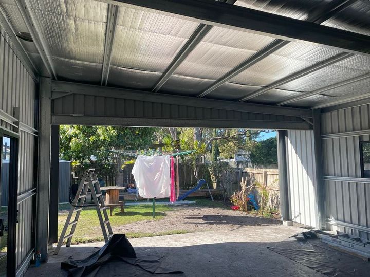 A Garage With a Ladder and Clothes Hanging on a Clothes Line — Providing Steel & Concrete Construction In Eviron, NSW