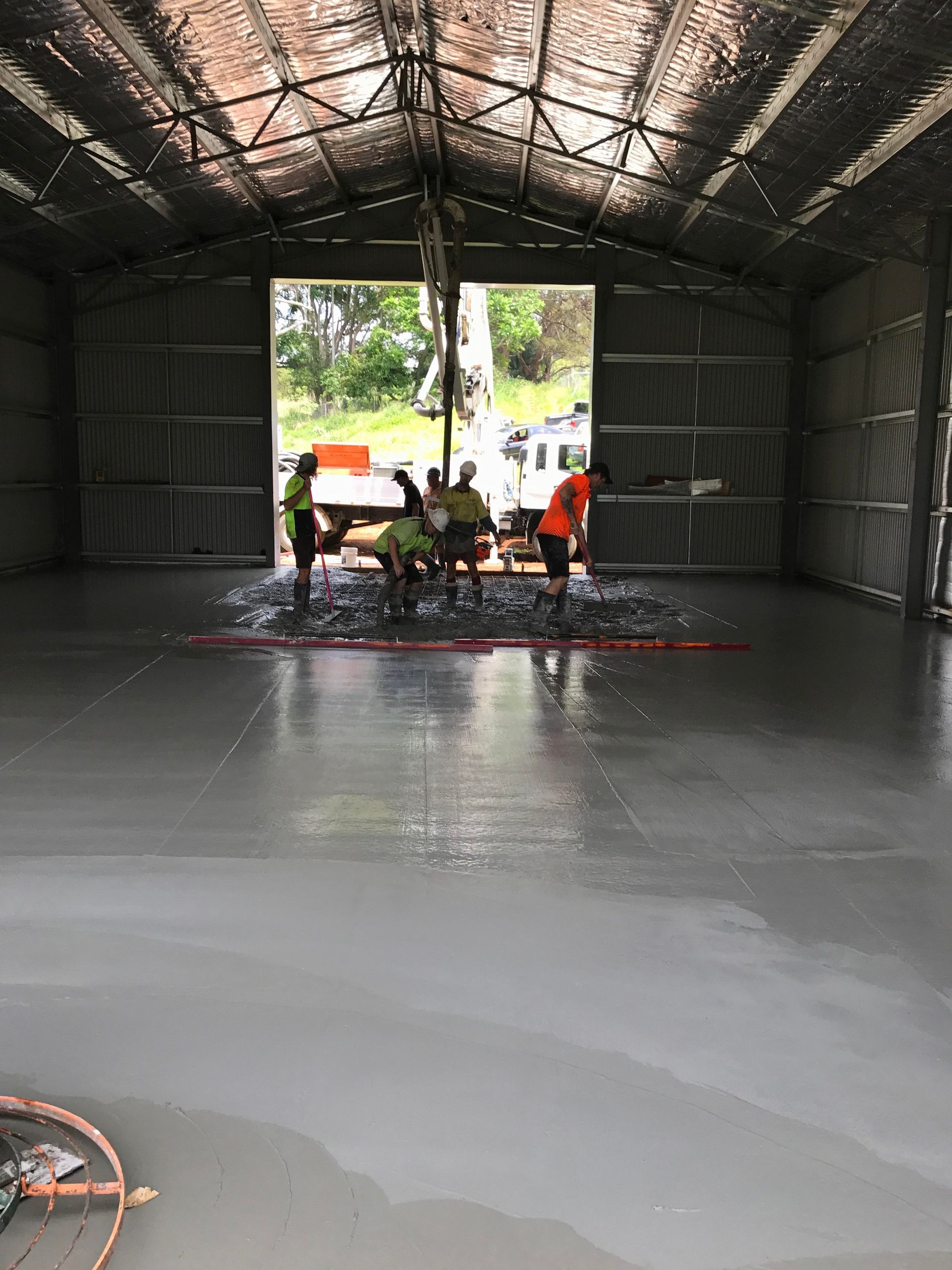 A Group of People are Working on the Floor of a Building — Providing Steel & Concrete Construction In Eviron, NSW