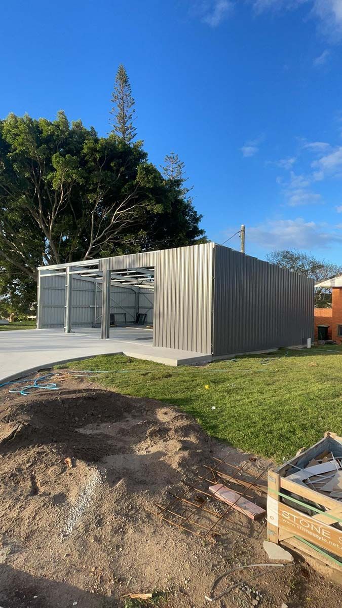Large Metal Building Is Being Built In The Middle Of A Grassy Field — Providing Steel & Concrete Construction In Eviron, NSW