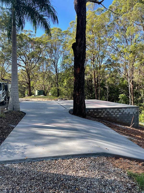 A Concrete Driveway With A Tree In The Middle Of It — CJR Group Concrete Construction In Byron Bay, NSW