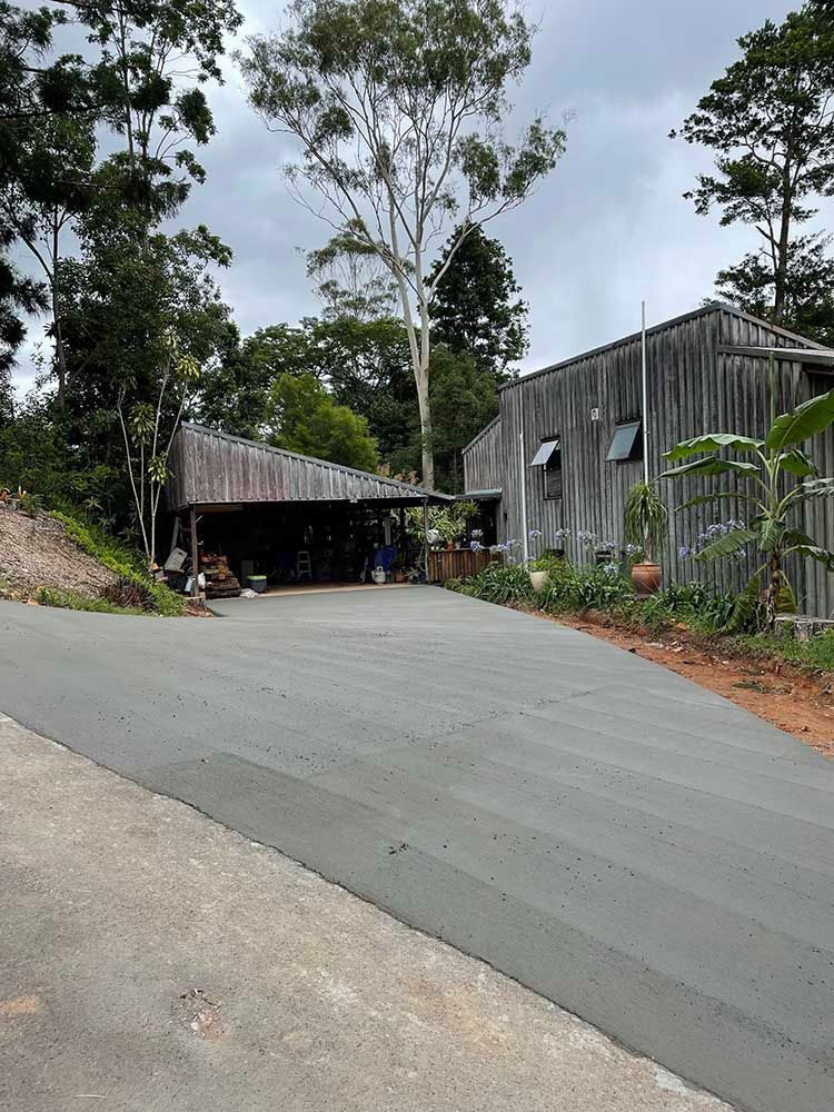 Road Leading To A House With A Carport And Trees On The Side Of It — Providing Steel & Concrete Construction In Byron Bay, NSW
