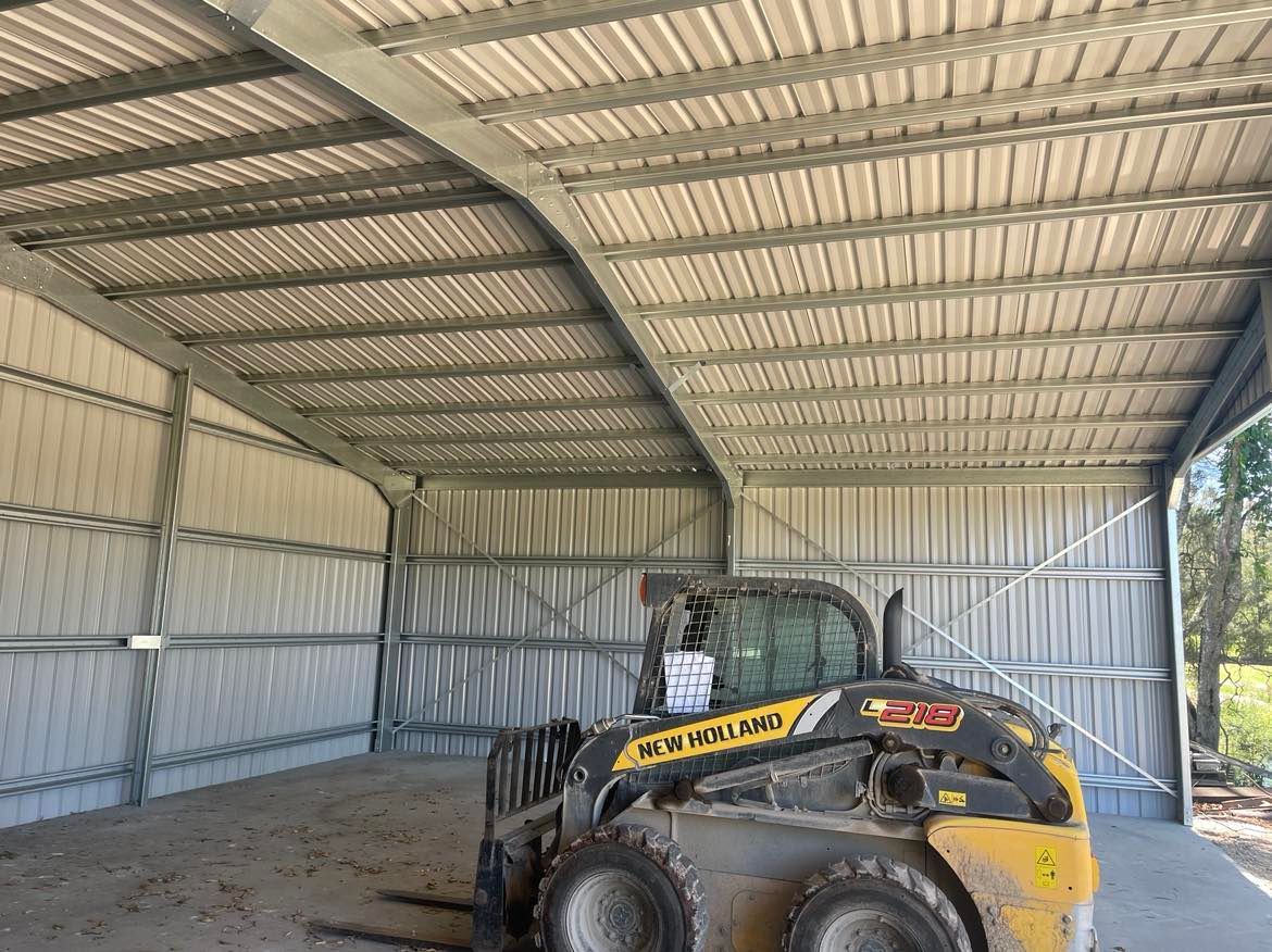 Bulldozer Is Parked Inside Of A Metal Building — Providing Steel & Concrete Construction In Tweed Heads, NSW