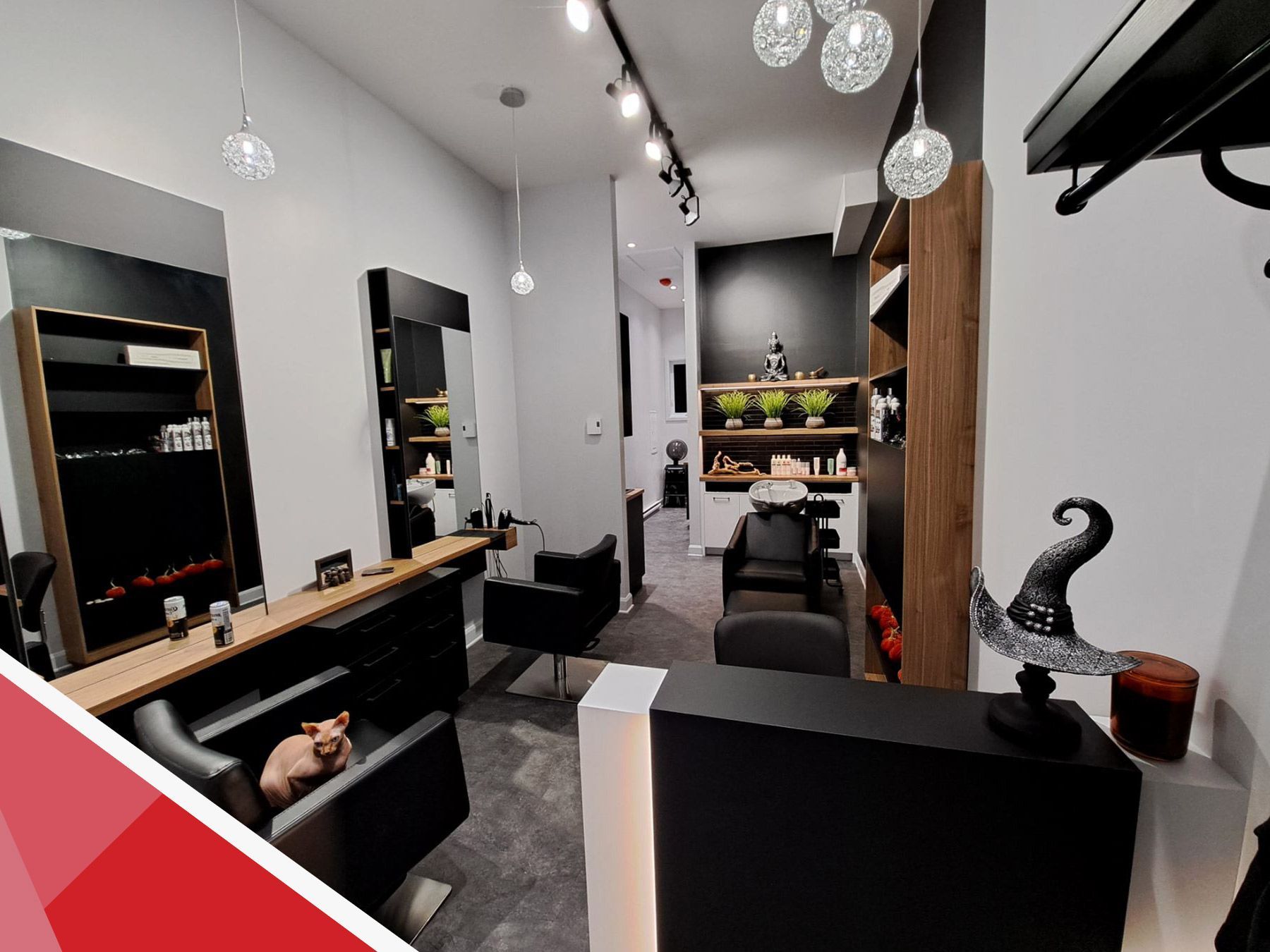 Intérieur moderne d'un salon de coiffure avec fauteuils de coiffure, miroirs, étagères et éclairage, vu depuis la réception.