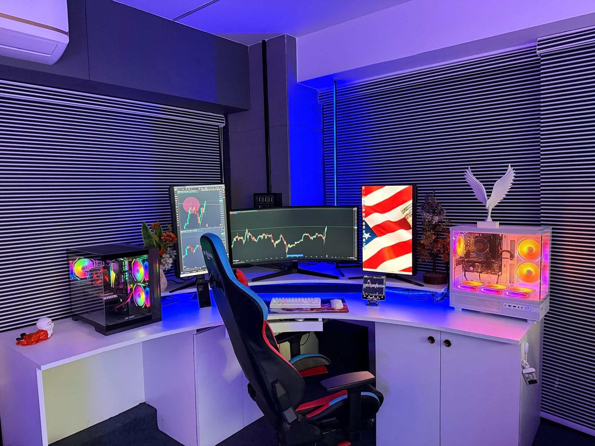 Gaming desk setup with dual monitors, RGB lighting, white cabinets, and a black chair in a purple-lit room