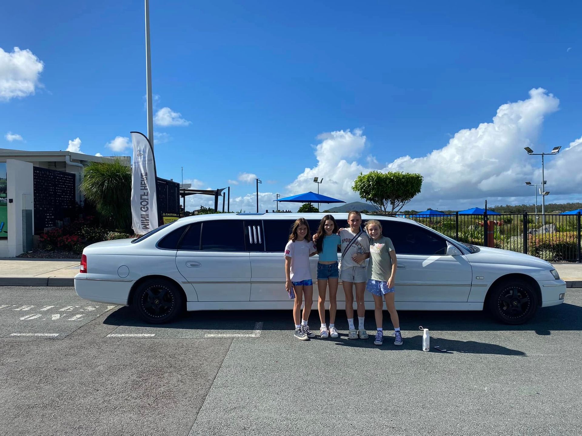 A Group of People Are Posing for a Picture in a  Limousine — Noosa Premier Stretch Holden Transfers In Sunrise Beach, QLD