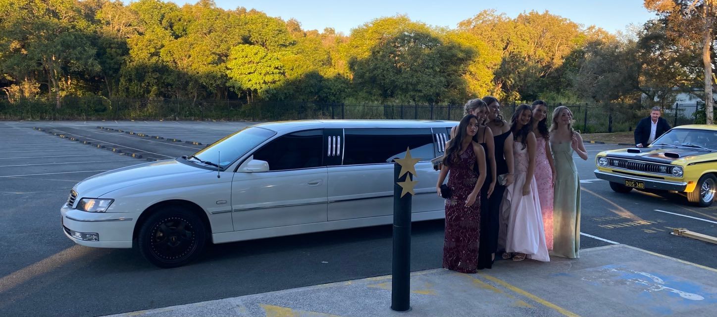 A Group of Girls Are Standing in Front of a White Limousine — Noosa Premier Stretch Holden Transfers In Sunrise Beach, QLD